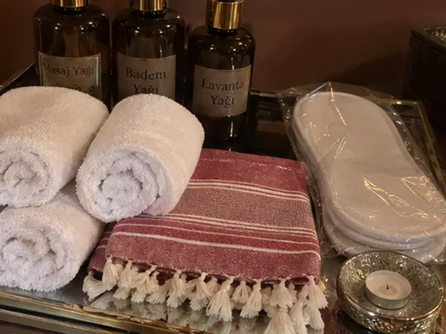 Masaj yağları, rulo havlular, kırmızı çizgili peştemal ve terlik — Tarlabaşı, Masaj Salonun
